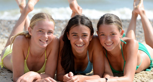 Estudiantes en la playa en Exmouth durante un viaje de idiomas con LISA! tumbadas en la arena disfrutando del sol y el mar