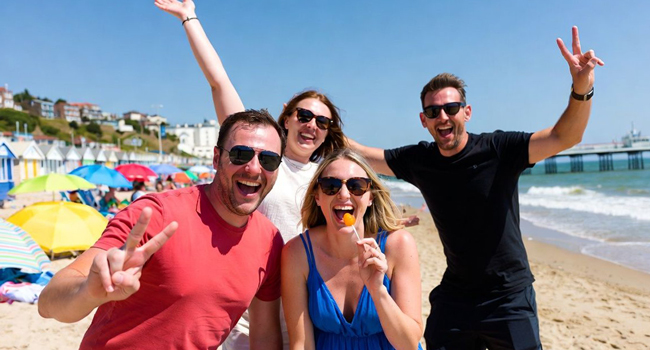  Participantes adultos divirtiéndose en la playa de Bournemouth durante un viaje de idiomas con LISA! en Inglaterra