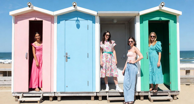 Viajes de idiomas en Inglaterra Bournemouth con LISA! – casetas de playa, mar y tiempo libre relajado Adultos frente a coloridas casetas de playa en Bournemouth Inglaterra durante un viaje de idiomas con LISA! disfrutando del mar