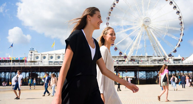 Viajes de idiomas en Inglaterra Bournemouth con LISA! – paseo marítimo, ocio y experiencias internacionales Participantes femeninas en un viaje de idiomas en Bournemouth Inglaterra caminando por el paseo durante un viaje con LISA!
