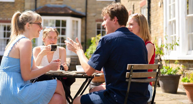 Participantes adultos disfrutando de una pausa en un café en Bournemouth durante un viaje de idiomas con LISA! en Inglaterra