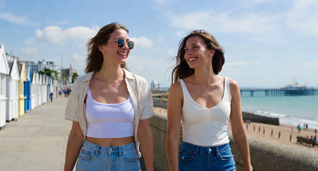 Viajes de idiomas para adultos en Inglaterra Brighton con LISA! – paseo marítimo, mar y tiempo libre Dos participantes caminando por el paseo marítimo en Brighton durante un viaje de idiomas con LISA! en Inglaterra
