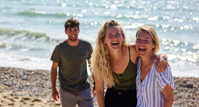  Participantes adultos riendo en la playa de Brighton durante un viaje de idiomas con LISA! en Inglaterra