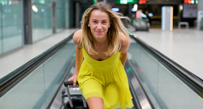 Estudiante con maleta camino a un viaje de idiomas con LISA! en el aeropuerto