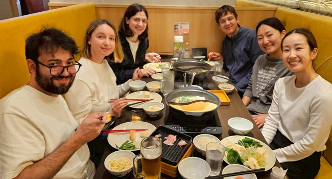 Vacaciones educativas Osaka Japón con LISA! – aprender japonés, gastronomía y experiencias compartidas Adultos comiendo juntos en un restaurante en Osaka durante unas vacaciones educativas con LISA! descubriendo la cocina japonesa y el ambiente internacional