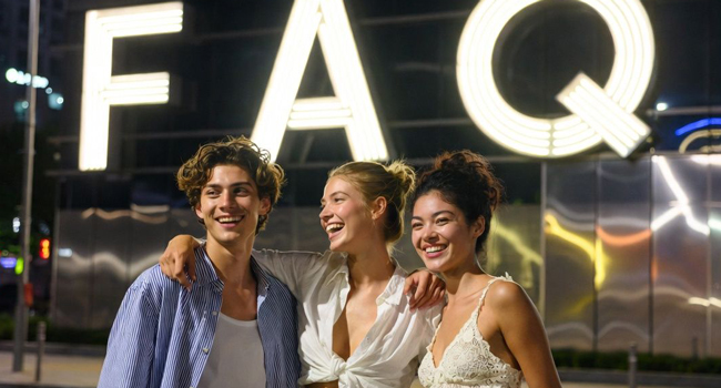  Jóvenes adultos frente a un letrero luminoso FAQ en Seúl por la noche durante un viaje de idiomas con LISA! disfrutando de la vida nocturna