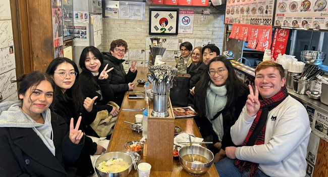  Adultos comiendo juntos en un restaurante en Seúl durante un viaje de idiomas con LISA! disfrutando de la cocina coreana en grupo
