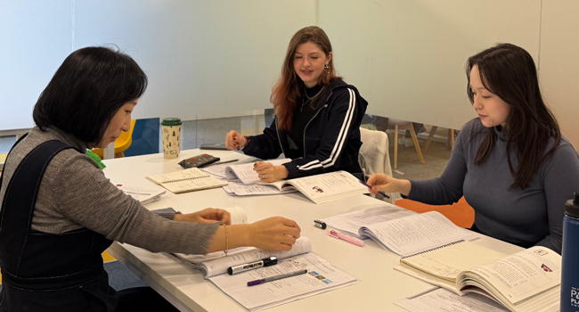 Adultos estudiando coreano en Seúl durante un viaje de idiomas con LISA! aprendiendo juntos con libros y materiales en clase