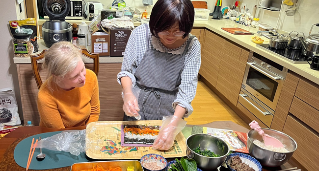 Adultos cocinando con una familia anfitriona en Seúl durante un viaje de idiomas con LISA! experimentando la cocina coreana