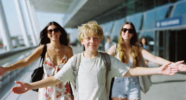 Llegada niño en el aeropuerto con su familia Llegada niño en el aeropuerto de Bangkok con su familia