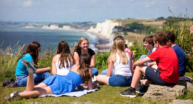Viajes de idiomas en Inglaterra Eastbourne con LISA! – ocio, naturaleza y costa impresionante Grupo de estudiantes en Eastbourne Inglaterra durante un viaje de idiomas con LISA! sentados en los acantilados con vista al mar