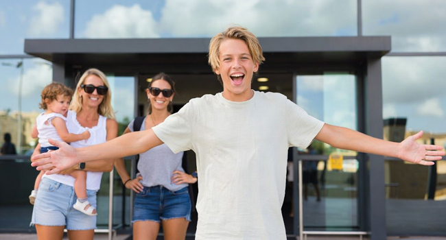 Llegada a un viaje de idiomas para estudiantes en Inglaterra Brighton con LISA! – estudiante saluda a su familia Estudiante llegando al aeropuerto entusiasmado por un viaje de idiomas con LISA! para estudiantes en Inglaterra Brighton