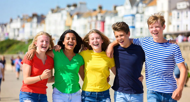 Viajes de idiomas en Inglaterra Eastbourne con LISA! – playa, amistades y experiencias inolvidables Grupo de estudiantes en la playa en Eastbourne Inglaterra durante un viaje de idiomas con LISA! disfrutando del tiempo juntos junto al mar