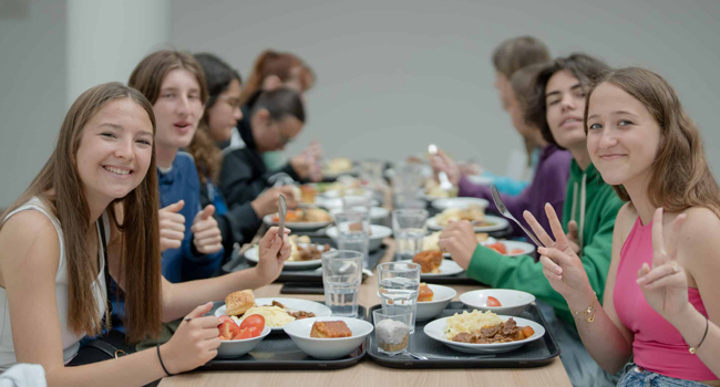 Viajes de idiomas en Inglaterra Eastbourne con LISA! – alojamiento, comidas y convivencia Estudiantes en la cafetería en Eastbourne Inglaterra durante un viaje de idiomas con LISA! comiendo juntos en el alojamiento