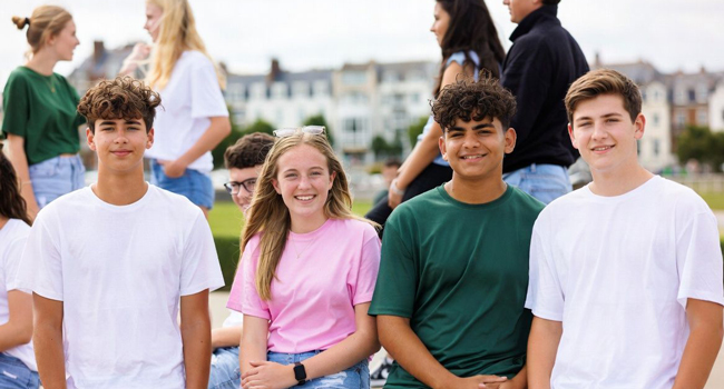 Grupo de estudiantes en Exmouth durante un viaje de idiomas con LISA! sentados juntos al aire libre disfrutando del apoyo y la convivencia