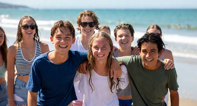  Grupo de estudiantes en la playa en Exmouth durante un viaje de idiomas con LISA! disfrutando del ocio, el mar y experiencias juntos
