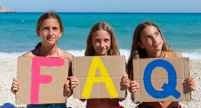 Estudiantes en Jersey sostienen letras FAQ en la playa durante un viaje de idiomas con LISA! con el mar de fondo