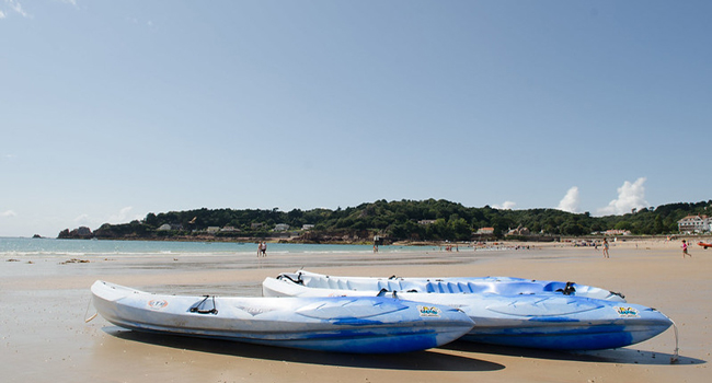  Playa en Jersey con kayaks junto al mar durante un viaje de idiomas con LISA! para estudiantes con programa de ocio
