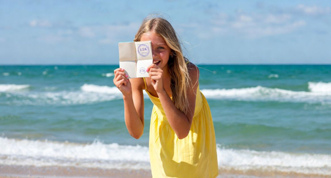 Estudiante en la playa en Portsmouth durante un viaje de idiomas con LISA! mostrando documento de entrada a Inglaterra