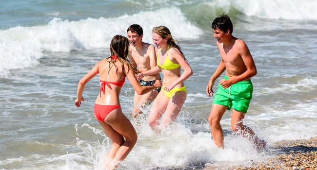  Estudiantes bañándose en el mar en Portsmouth durante un viaje de idiomas con LISA! disfrutando del ocio y la diversión en la playa