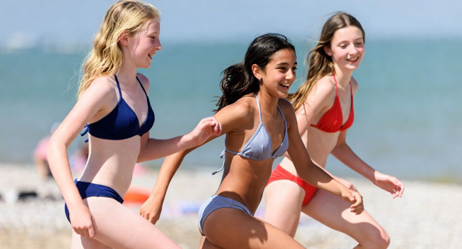 Estudiantes en la playa en Portsmouth durante un viaje de idiomas con LISA! corriendo junto al mar y disfrutando del tiempo libre