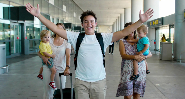  Estudiante llegando al aeropuerto con los brazos levantados emocionado por un viaje de idiomas con LISA! para estudiantes