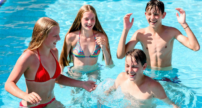 Cuatro estudiantes divirtiéndose en la piscina durante un viaje de idiomas con LISA! para estudiantes en Malta