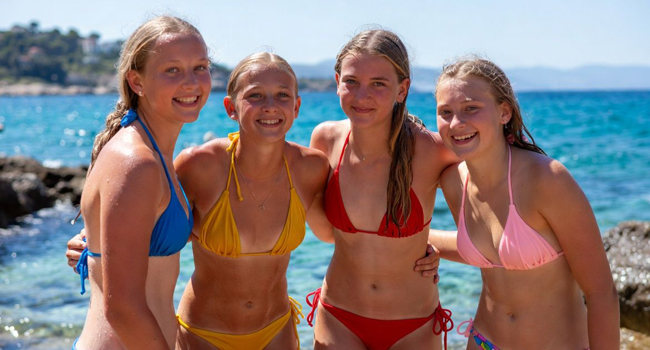 Cuatro chicas junto al mar en bikinis de colores en un viaje de idiomas en Malta San Gwann
