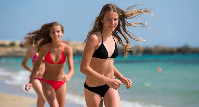 Viajes de idiomas para estudiantes en Malta con LISA! – chicas en la playa en verano Dos chicas corriendo en la playa en Malta durante un viaje de idiomas con LISA! para estudiantes