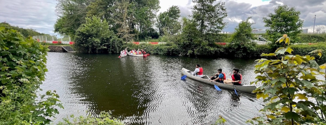 Eine Flusslandschaft in Devon mit zwei Paddelbooten und hohen Bäumen