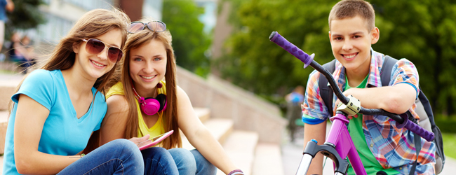 Irland erleben für Schüler und Jugendliche bei einer Schhülersprachreise in Galway Zwei Mädchen mit Kopfhörern und ein Junge mit Fahrrad bei einer LISA! Sprachreise in Galway