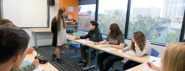 Unterricht an der Sprachschule in los Angeles Santa Monica Lehrerin hört auf einen Schüler im Klassenraum mit Ausblick auf Los Angeles