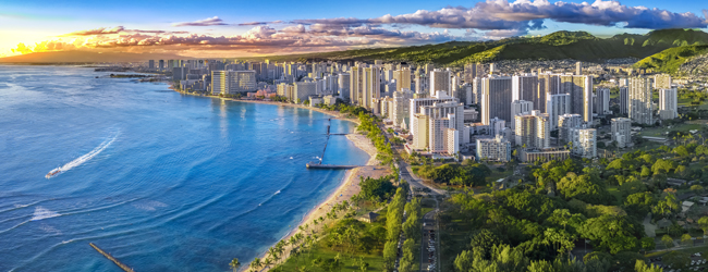 Blick auf Honolulu mit Sonnenuntergang während einer LISA! Sprachreise Englisch Luftbild von Honolulu auf Hawaii mit hohen Häusern und Meer bei Sonnenuntergang
