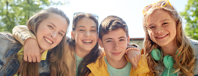 Neue Freundschaften auf einer Englisch-Sprachreise in Bath für Schüler Vier Jugendliche lächeln in die Kamera bei schönem Wetter auf einer Sprachreise für Schüler in Bath