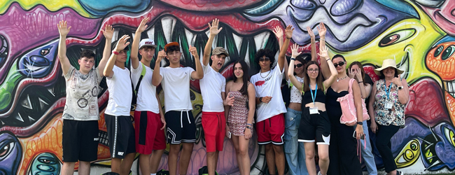 Jugendliche posieren vor einer kunstvoll gestalteten Wand in Miami