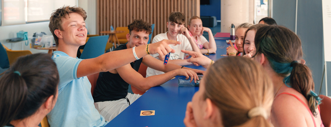 Pause in der LISA! Sprachschule in Barcelona Mehrere Schüler sitzen um einen Tisch und sprechen erfreut miteinander in der LISA! Sprachschule Barcelona